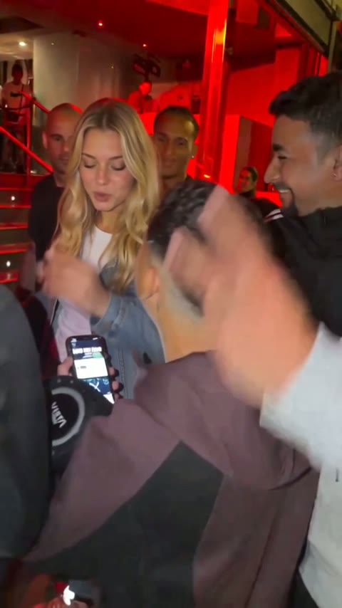 Gente apretujada en una puerta mientras una mano entra en el cuadro