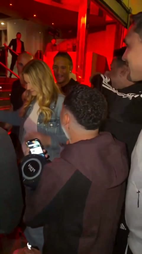 Rapero riéndose con un hombre que está a su lado