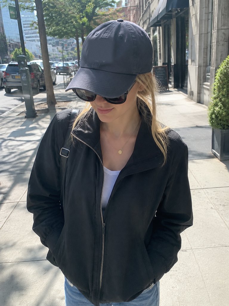 Face half hidden by dark sunglasses and the shadow of a cap